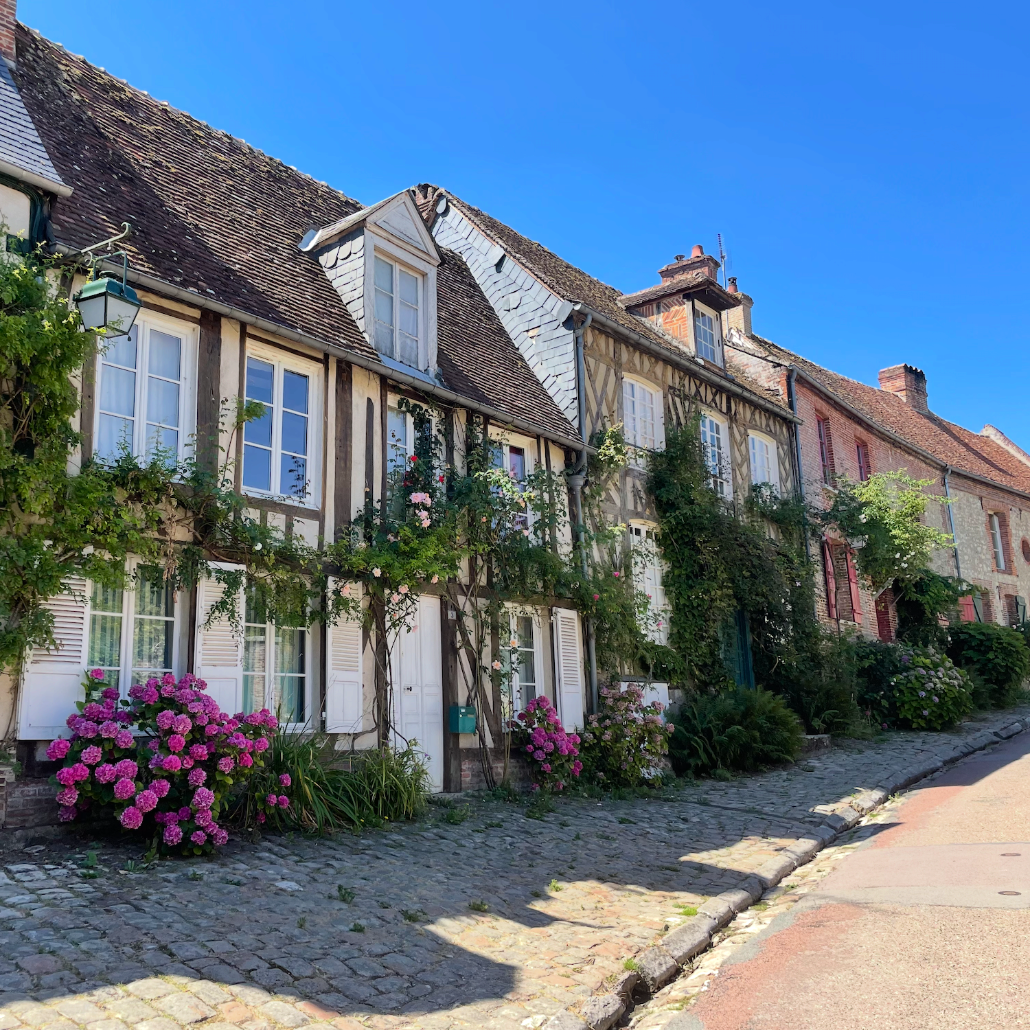 Ruelle pavée bordée de maisons à colombages à Gerberoy